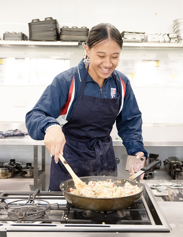 Girl cooking in the Emmaus Catholic College Kemps Creek kitchen
