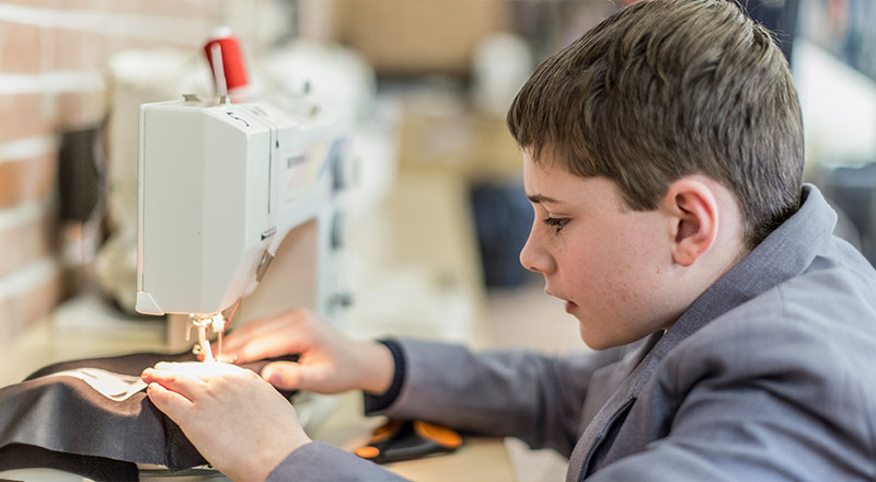 Boy using sewing machine at Emmaus Catholic College Kemps Creek