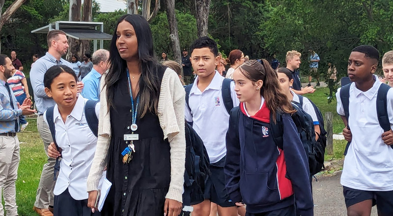 Teacher walking Emmaus Catholic College Kemps Creek students into school