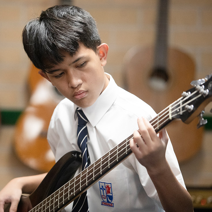 Student playing bass in the Emmaus Catholic College Kemps Creek music room