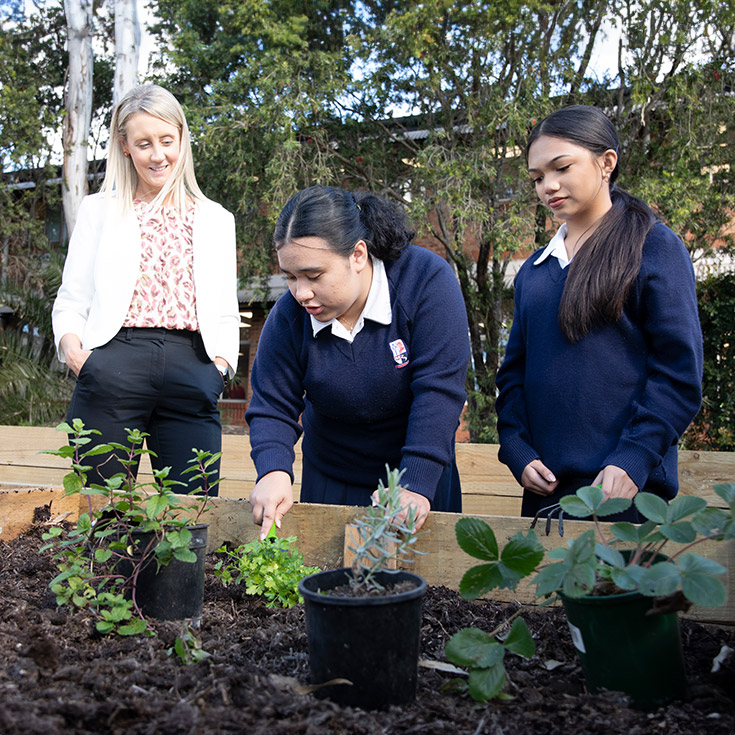 Emmaus Catholic College Kemps Creek teacher with students in the vege garden